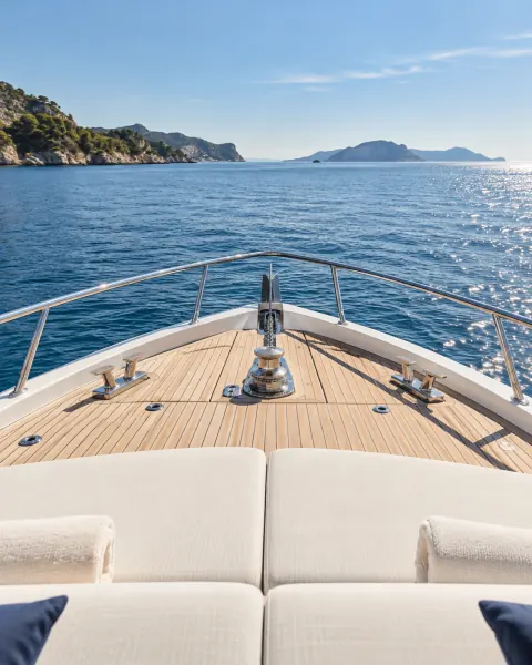 Prua in teak con battagliola verso una costa a picco sul mare